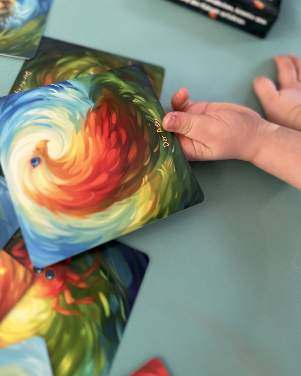 Bunte Tierkarten auf der Yogamatte, Kinderhand