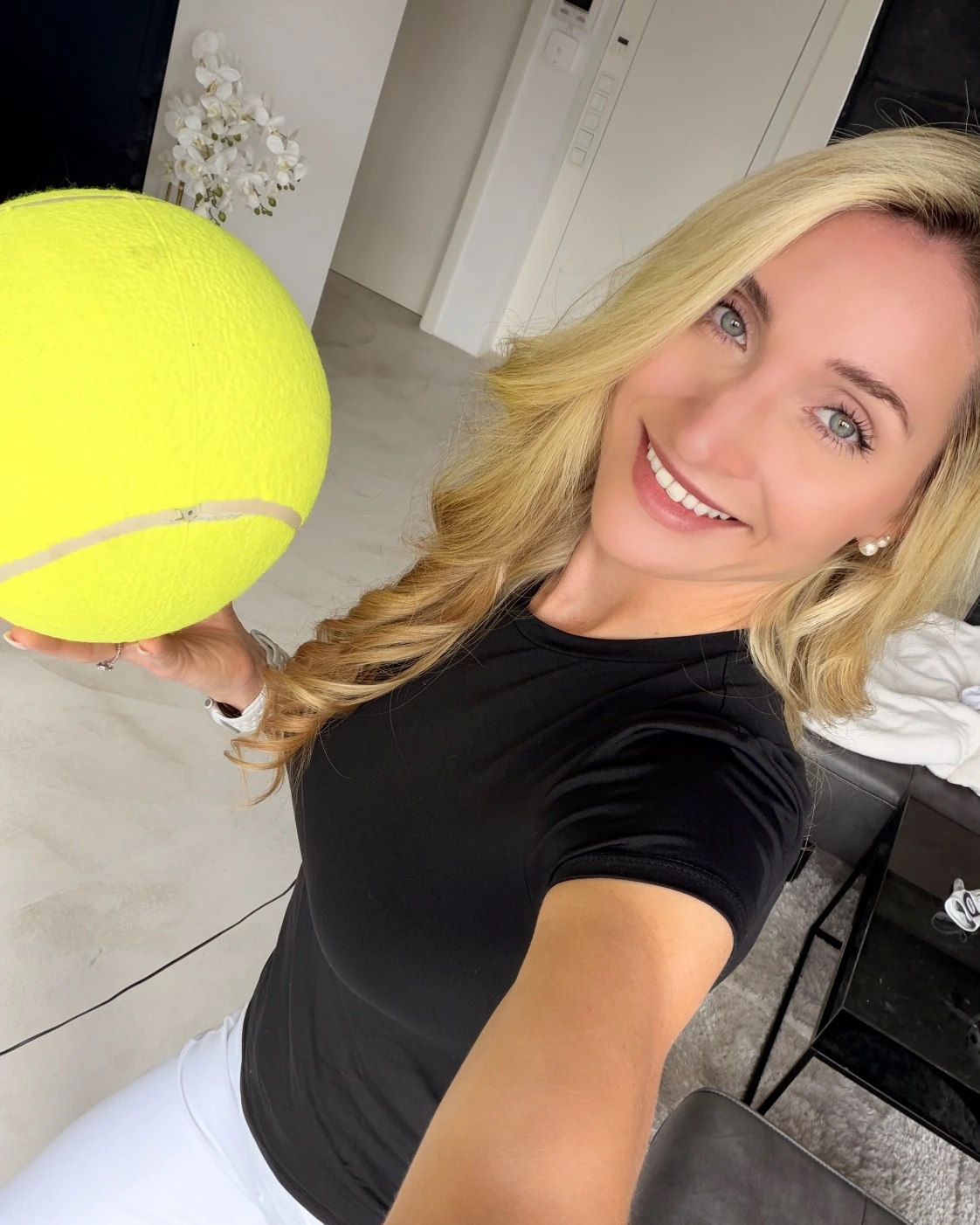 Teresa lächelt in die Kamera und hält einen großen gelben Ball